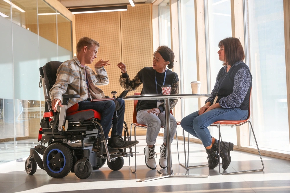 Disabled men on wheelchair with support providers